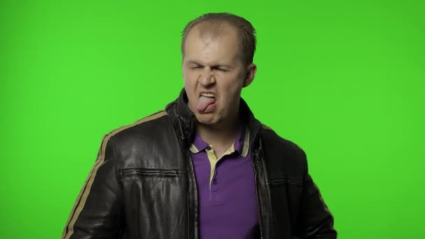 Aggressiver Rocker in brauner Lederjacke mit Zunge und verrücktem Gesichtsausdruck - Filmmaterial, Video