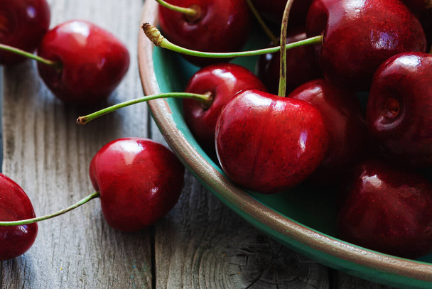 cherries in a bowl on wooden table closeup - Foto, Imagem