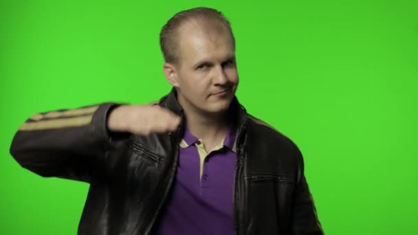 Rocker man saluting with hand and pretending to listen order. Guy biker on chroma key background - Footage, Video