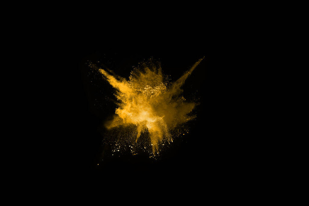 Замораживание движения взрыва желтой пыли на черном фоне. - Фото, изображение