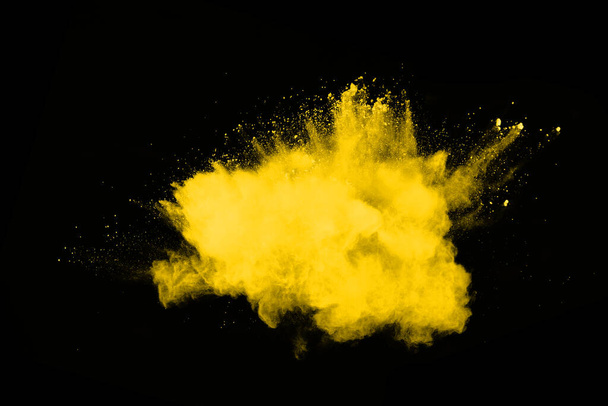 Mouvement de gel de l'explosion de poussière jaune isolé sur fond noir. - Photo, image