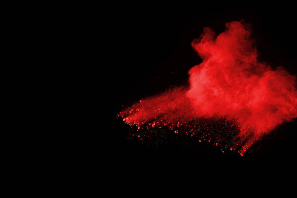 Взрыв красного порошка на черном фоне. Замораживание движения взрывающегося красного порошка. - Фото, изображение