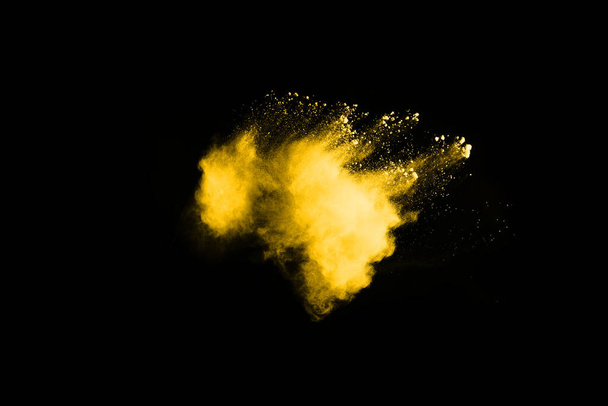 Freeze motion of yellow dust explosion isolated on black background. - Фото, зображення