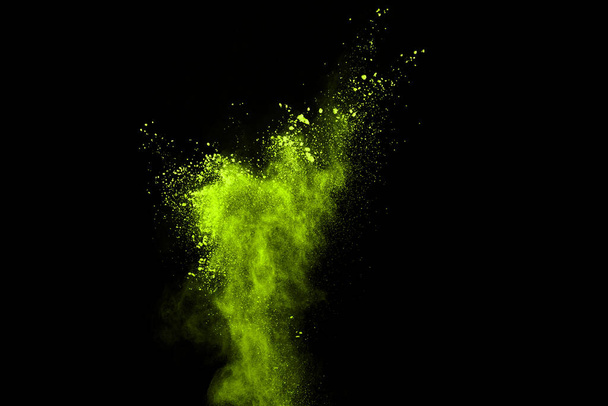 The movement of abstract dust explosion frozen green on black background. Stop the movement of powdered green on black background. Explosive powder green on black background. - Foto, imagen