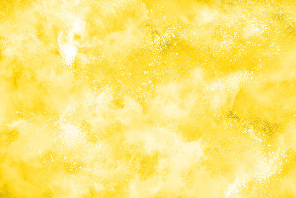 Poederexplosie. Close-up van een gele stofdeeltjes explosie geïsoleerd op wit. Abstracte achtergrond - Foto, afbeelding