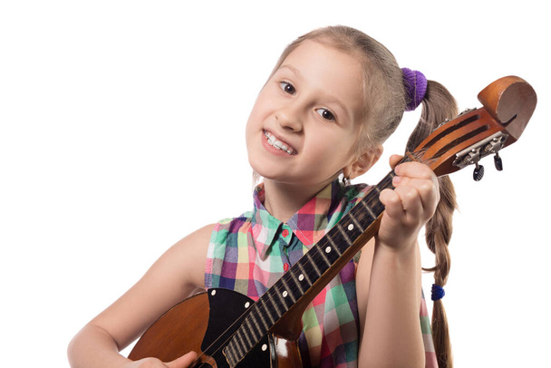 Χαριτωμένο κοριτσάκι που παίζει ντόμπρα. Φωτογραφία στούντιο. Υπόδειγμα που απομονώνεται σε λευκό φόντο - Φωτογραφία, εικόνα