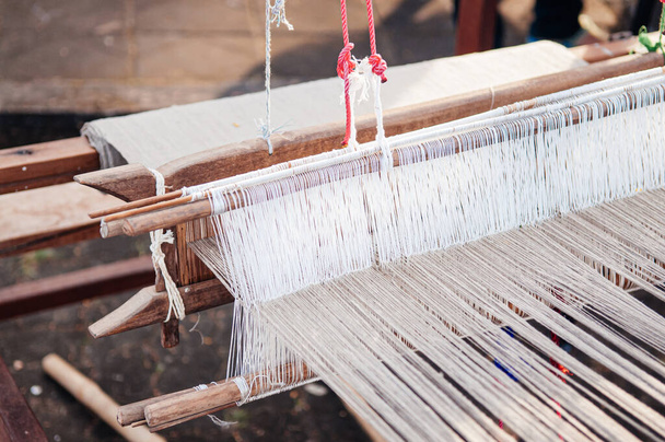 Ткацький верстат з натуральними кольоровими нитками місцеві тайські бавовняні тканини виробляють промисловість у сільській місцевості. - Фото, зображення