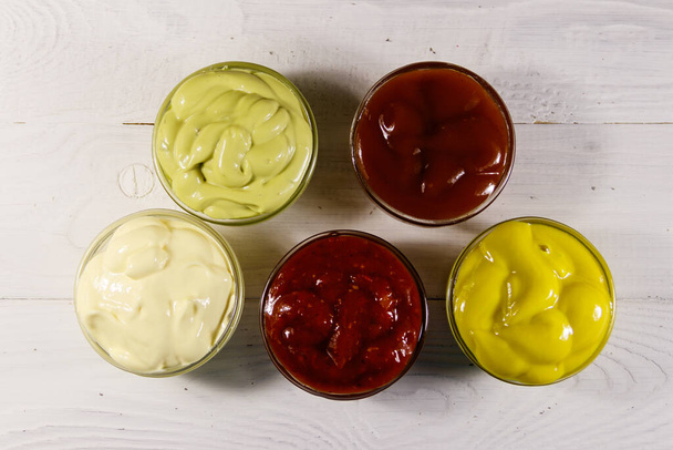 Set de salsas sobre mesa de madera blanca. Vista superior - Foto, Imagen