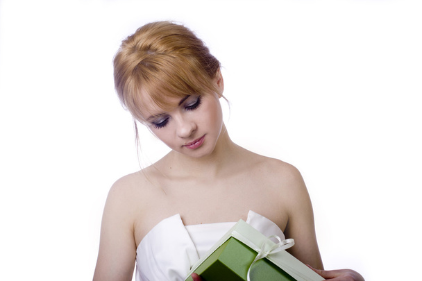 krásná mladá blondýnka v sexy šatech drží světlé dárek izolovaných na bílém pozadí - Fotografie, Obrázek