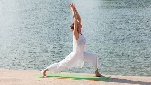 mulher adulta praticar ioga manhã de verão por lago
 - Foto, Imagem