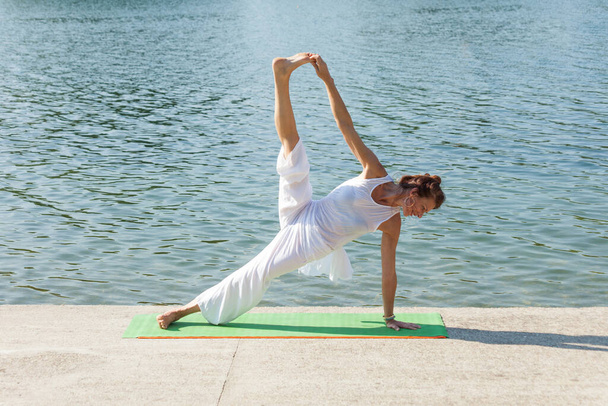  adult woman practice yoga summer morning by lake - Photo, Image