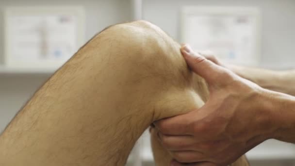 Filmación del hombre profesional haciendo fisioterapia en la rodilla
 - Imágenes, Vídeo