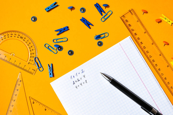 Mockup planner επίπεδη lay, κορυφή οριζόντια προβολή κίτρινο φόντο. Σημειωματάριο με γραφική ύλη. Μπλε, άσπρο και μαύρο χρώμα. Επιστροφή στο σχολείο, έννοια της εκπαίδευσης. Μαθηματικά κείμενα, σχολικά μαθήματα - Φωτογραφία, εικόνα
