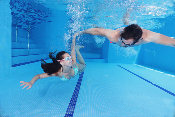 - Cute couple having fun underwater, swimming pool romance concept - Foto, immagini