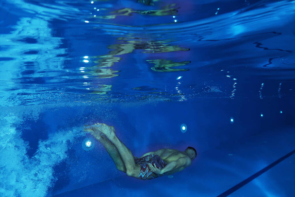 Underwater image of a swimmer in the swimming pool - Fotó, kép