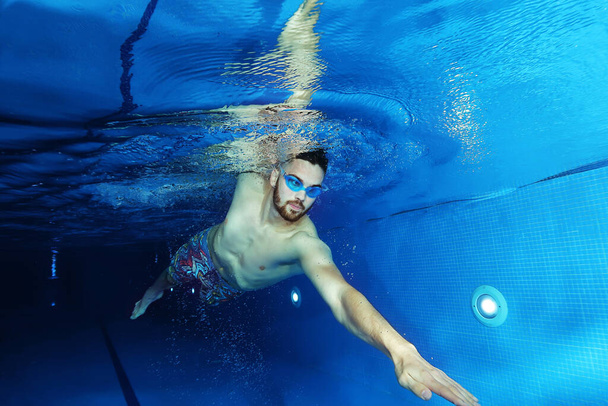 Handsome swimmer in the swimming pool, concept of underwater photography - Foto, Imagen