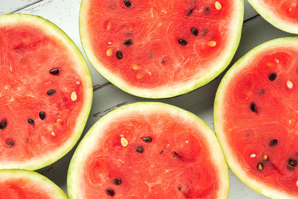 Runde Scheiben Wassermelone in Großaufnahme auf dem weißen Holztisch im provenzalischen Stil. - Foto, Bild