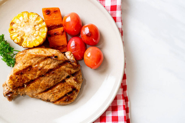 grilled and barbecue fillet pork steak with corn, carrot and tomatoes - Foto, Bild