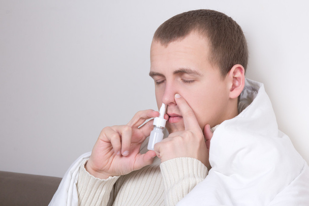 člověk s použitím nosní sprej ve svém obývacím pokoji - Fotografie, Obrázek
