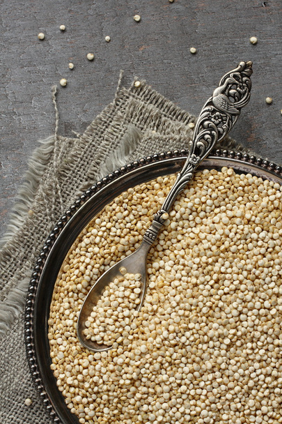 Uncooked quinoa in metal plate on wooden background - Photo, Image