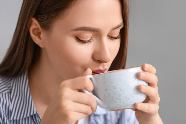 Красива молода жінка п'є чай вдома
 - Фото, зображення