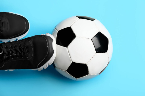 Fußball und Schuhe auf farbigem Hintergrund - Foto, Bild