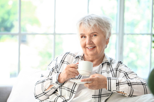 Senior woman drinking tea at home - Fotoğraf, Görsel