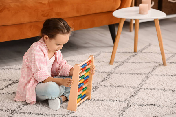 Kleines Mädchen mit autistischer Störung spielt zu Hause mit Abakus - Foto, Bild