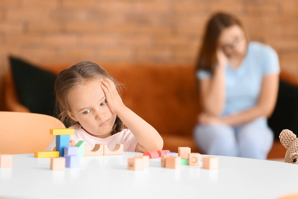 Sad little girl with autistic disorder playing with blocks at home - Foto, Imagem