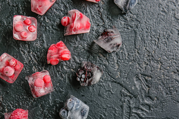 Ice with frozen berries on dark background - 写真・画像