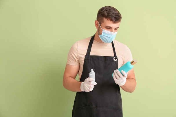 Male hairdresser wearing medical mask on color background. Coronavirus epidemic - Photo, image