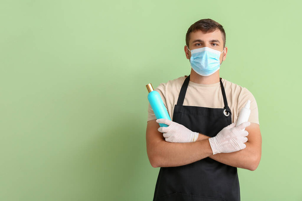 Άνδρας κομμωτής φορώντας ιατρική μάσκα στο φόντο χρώμα. Επιδημία του κορωναϊού - Φωτογραφία, εικόνα