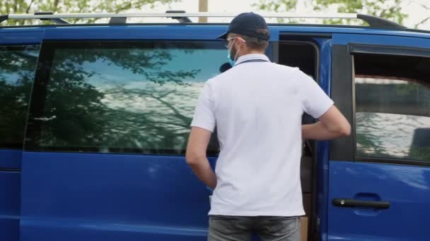 Un fattorino usa una tavoletta vicino al furgone - Filmati, video