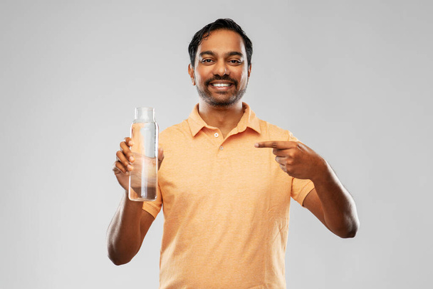 happy indian man showing water in glass bottle - Foto, Imagem