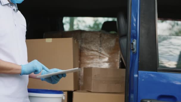 Delivery man with a tablet checks his cargo count, closeup - Footage, Video