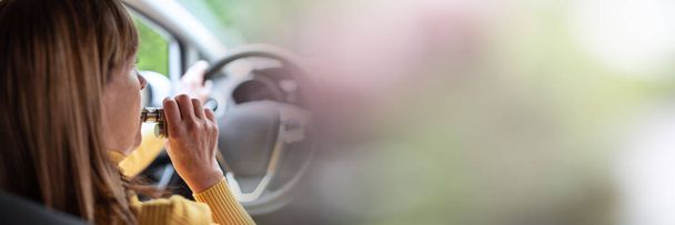 Woman smoking an e-cigarette while driving; panoramic banner - Photo, Image
