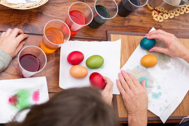 topview on a table with easter eggs and colorful dye, hands of two women - Fotó, kép