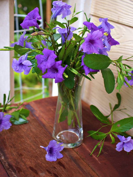 Piękne purpurowe kwiaty w wazonie na drewnianym stole, tło bukiet - Zdjęcie, obraz