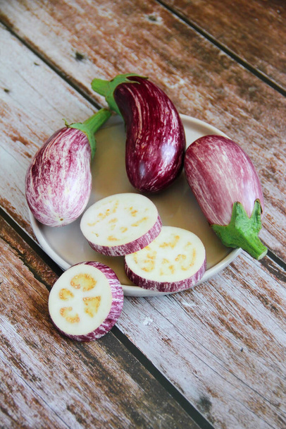 proužkovaný kaštanový lilek a jeho kousky na dekorativním talíři - Fotografie, Obrázek