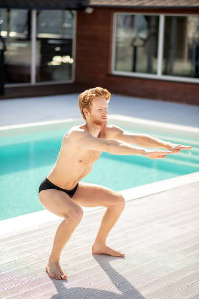Attractive young man doing sports near pool - Foto, immagini