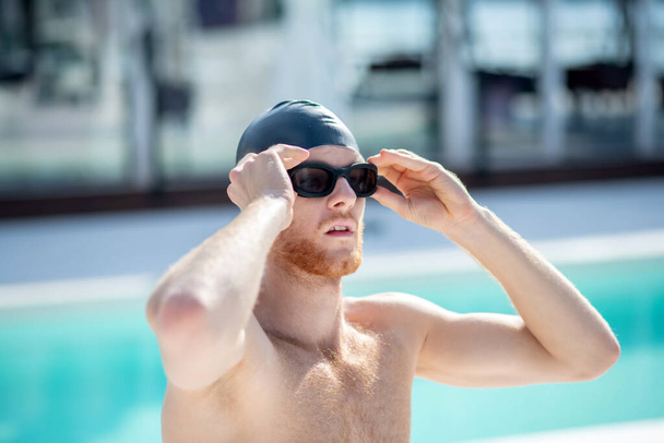 Serious swimmer in swimming goggles near the pool - Fotoğraf, Görsel