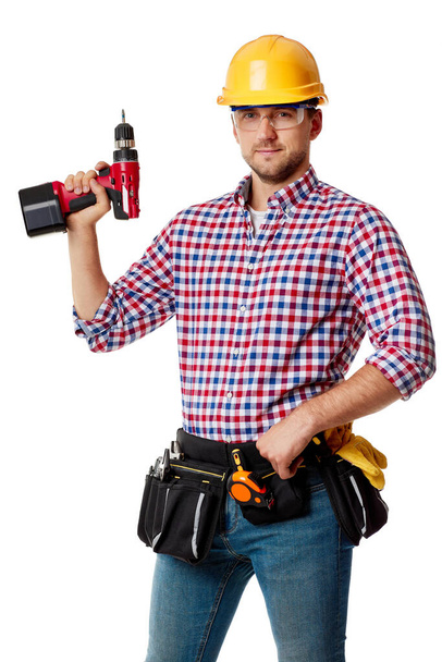 worker in yellow hard hat holding cordless screwdriver. - Fotografie, Obrázek