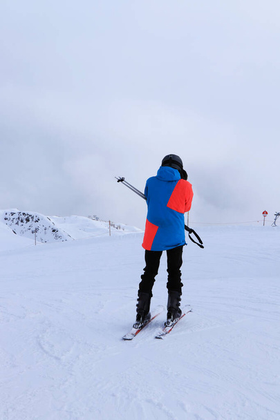 Jeune skieur met des lunettes pour une meilleure visibilité dans de mauvaises conditions sur la piste située à la frontière entre l'Italie et l'Autriche, station de ski Sillian. Station de ski Sillian à Hochpustertal Valley, Tyrol. - Photo, image