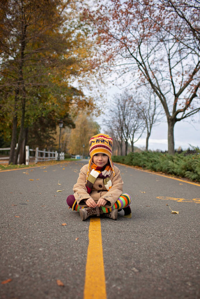 Herfst vibes, hallo herfst. Stijlvol 7-jarig meisje wandelen in het lege park tussen de gouden bomen, sociale afstand, familie weekend, prachtige natuur buiten - Foto, afbeelding