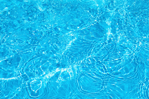 Крупный план грубой поверхности воды с брызгами и пузырьками синего цвета. Модный свежий абстрактный фон.  - Фото, изображение
