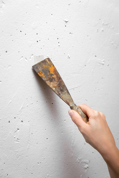 close up, woman hand with putty knife repairing a wall, handywoman, renovation at home, copyspace - Foto, Bild