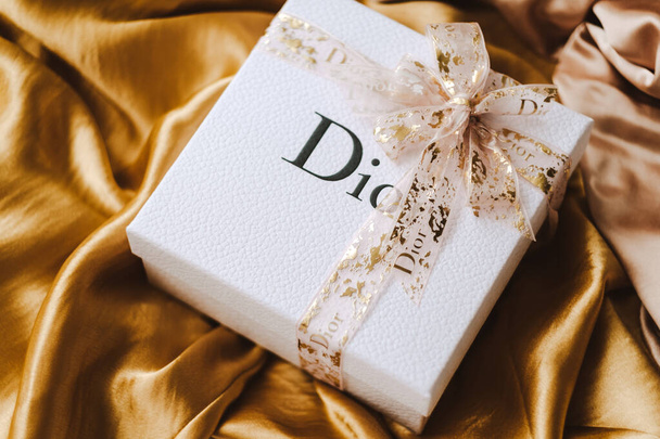 Gift box from DIOR with makeup on a golden fabric. High quality photo - Fotoğraf, Görsel