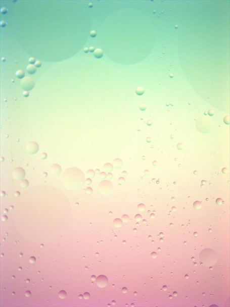 Primer plano verde azul luz hermosa burbujas aceite con color rosa dulce, imagen macro, fondo abstracto, fondo de pantalla brillante, gotas de agua borrosa, color pastel - Foto, imagen