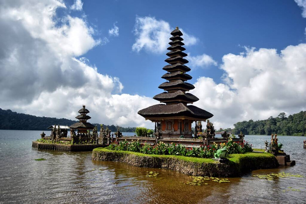Dağlar, bitki örtüsü ve gölle çevrili Bali tapınağı - Fotoğraf, Görsel