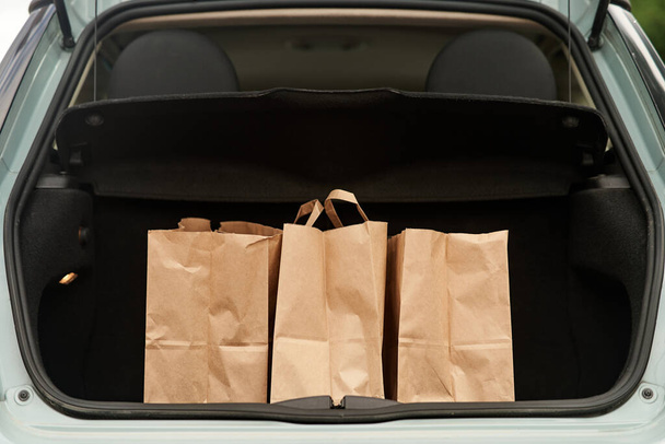Blank paper bags in a car trunk - Фото, зображення